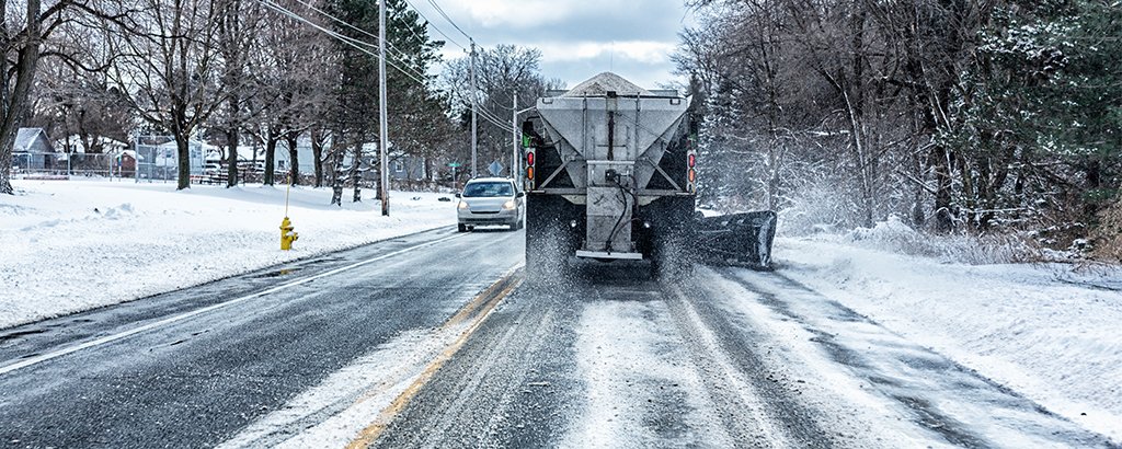 Snow plow plowing a winter road
