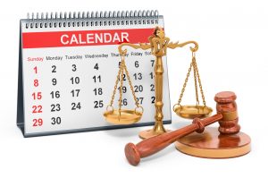 Desk calendar with wooden gavel and scales of justice.