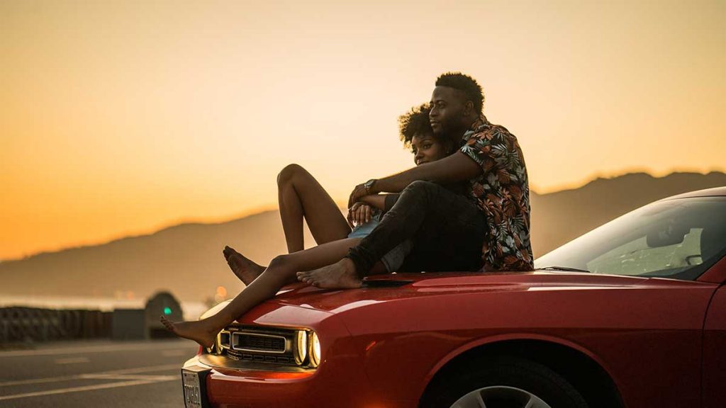Photo of couple sitting on car hood on a Valentine