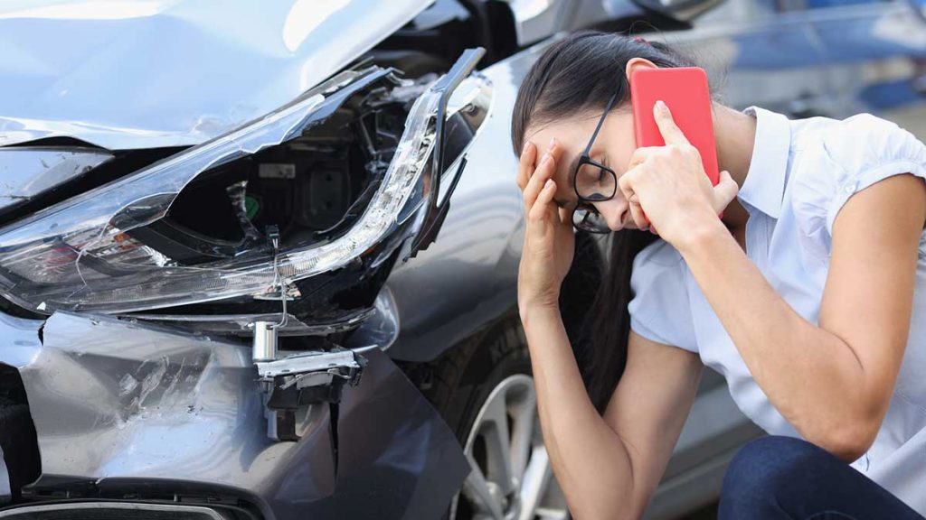 Upset woman on cell phone talking about a car accident without insurance