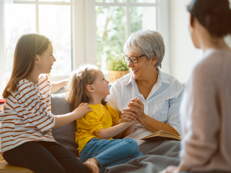 Grandmother happily laughing with grandchildren.