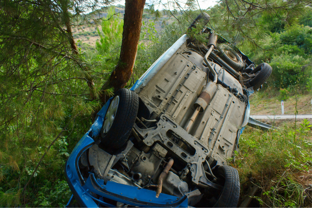 Upside down vehicle after car accident on forest road