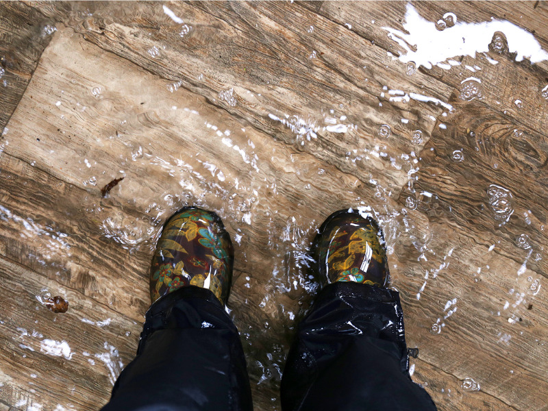 Woman wearing waterproof boots standing in a flood home