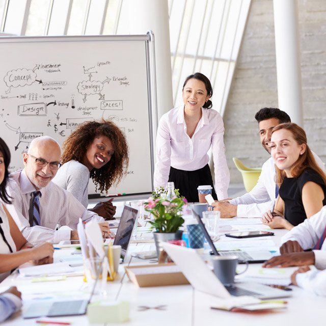 A diverse group meeting with a mix of young, old, female and male individuals sitting at a table