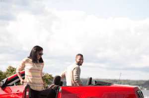 couple getting out of red car