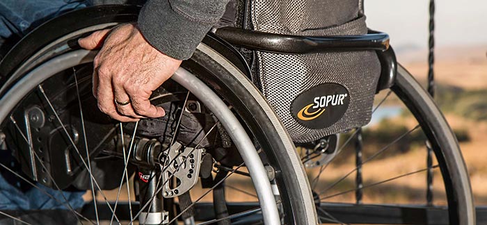 Image of older man holding the wheel of his wheelchair for Quotacy blog Disability Insurance: Why It’s Important for Workers.