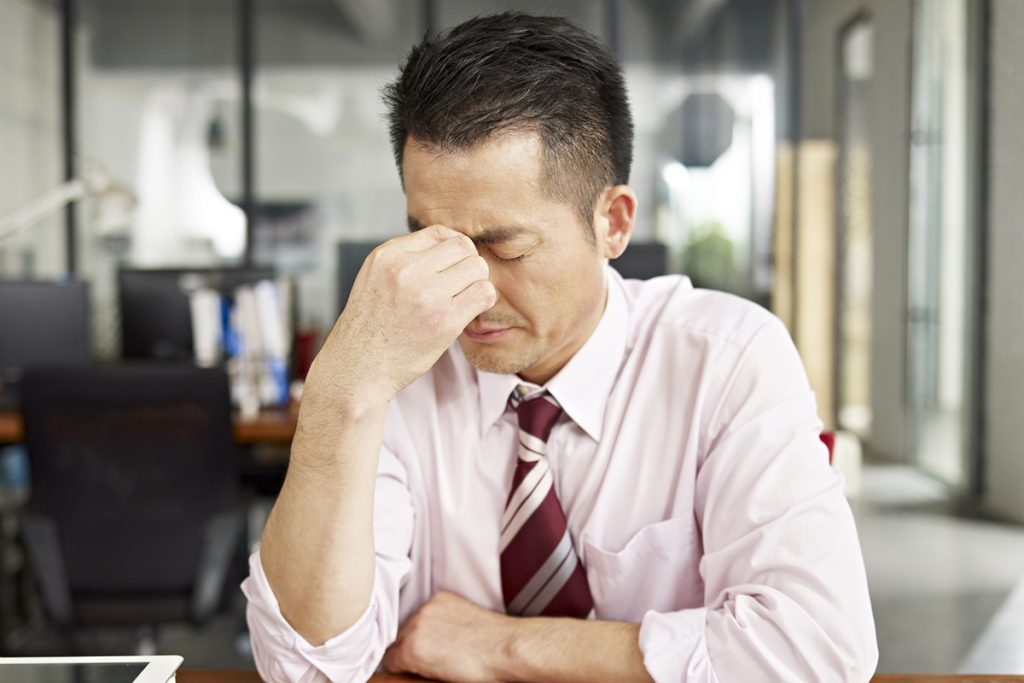 A businessman suffers a headache at work