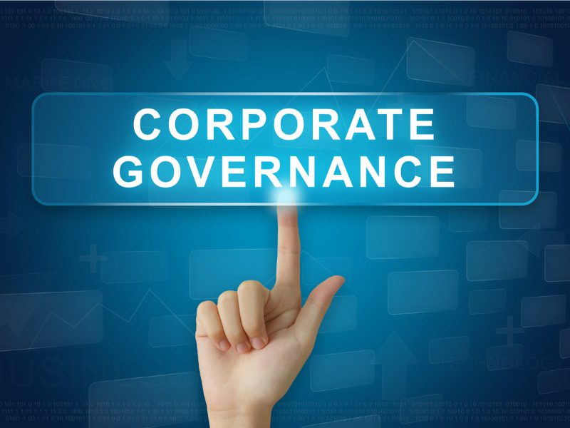 Hand pressing on corporate governance button