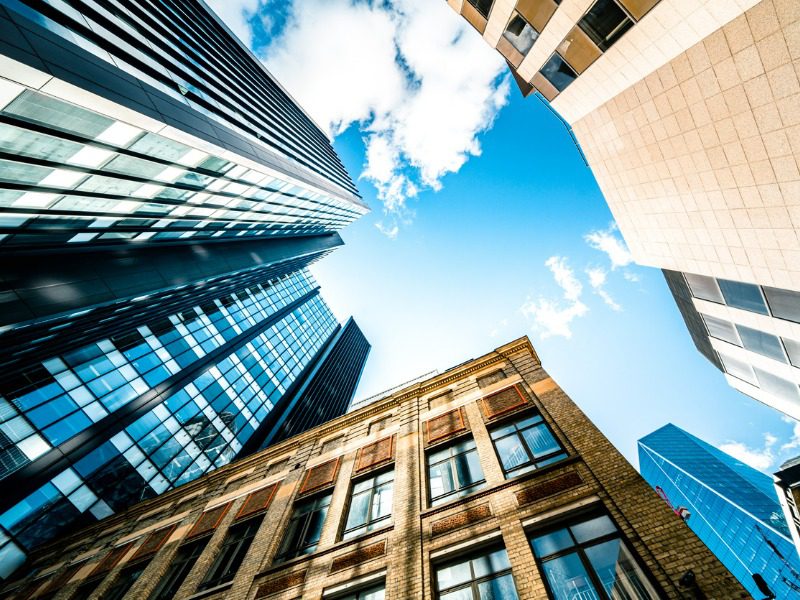 View of high rise glass building and dark steel window system on blue clear sky background