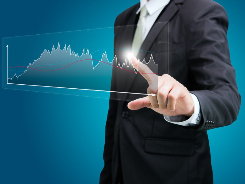 Businessman touching a graph displaying financial results