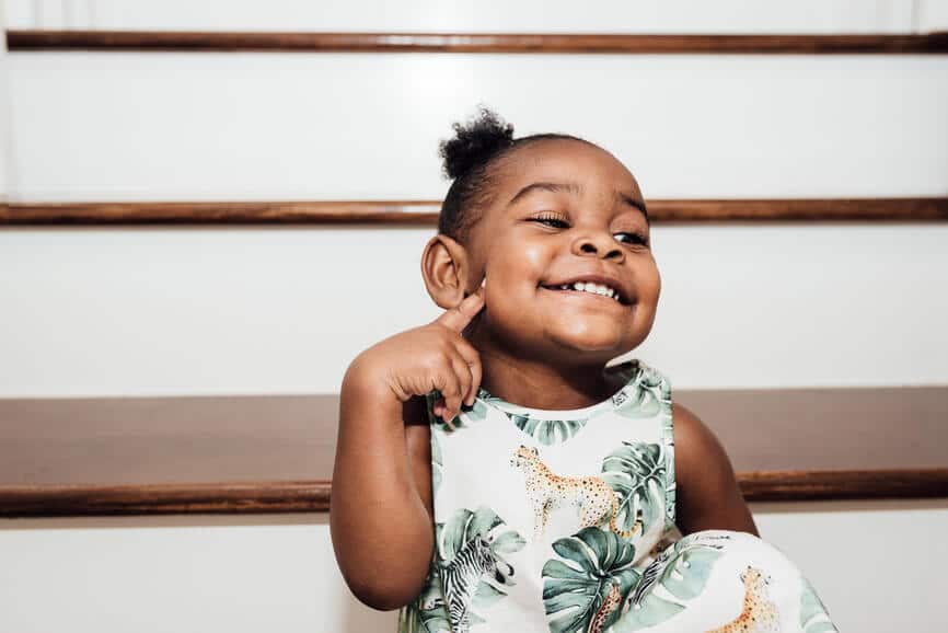 Black toddler girl smiling on the stairs