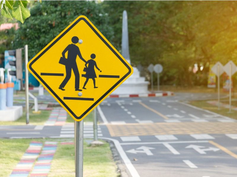 School crossing sign in front of an empty road