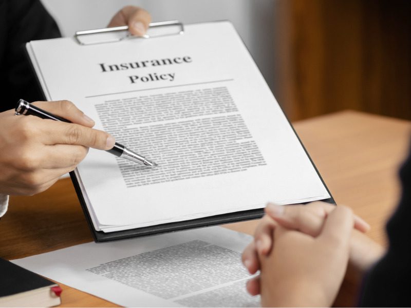 Insurance agent with a client to sign an insurance policy