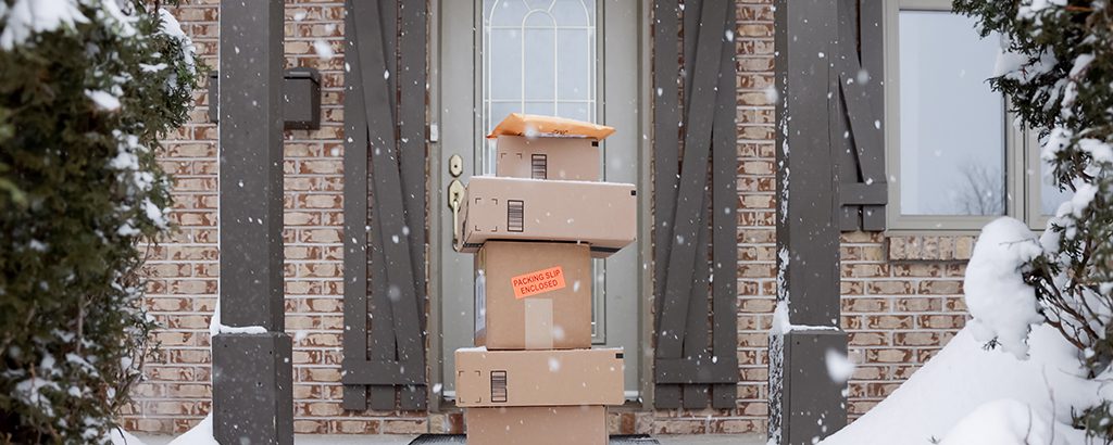 large stack of delivered boxes sitting on front step of home