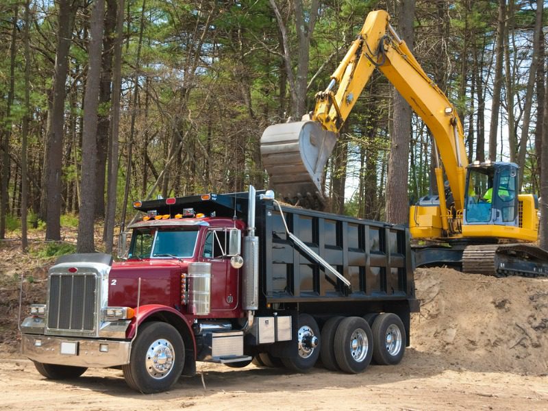 Excavator filling the bed of a dump truck