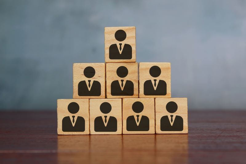 Blocks in a pyramid shape with silhouettes of executives