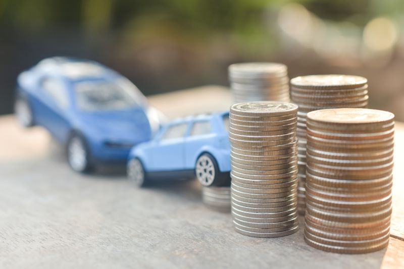 Toy cars crashing next to a pile of coins