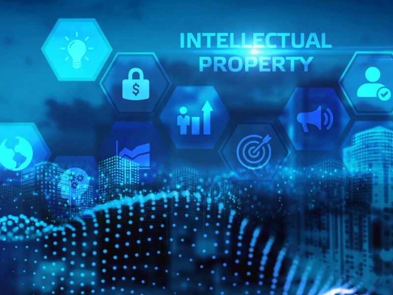 A virtual screen shows the words intellectual property, along with a lightbulb, padlock, target, megaphone and other various icons