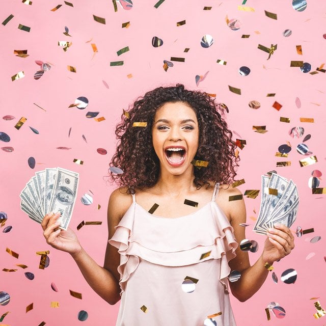 Woman holding cash in both hands with falling confetti