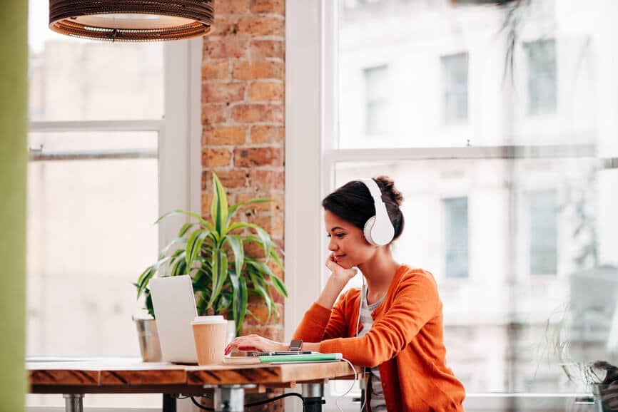 Stock Photo Of Woman Smiling In Front Of Laptop. She Is Having Video Conference From Home.