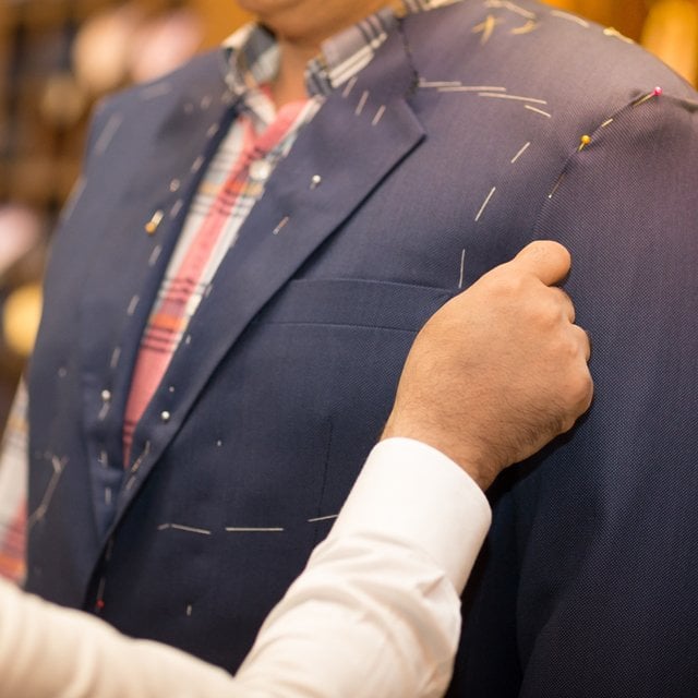 Tailor working with custom made suit