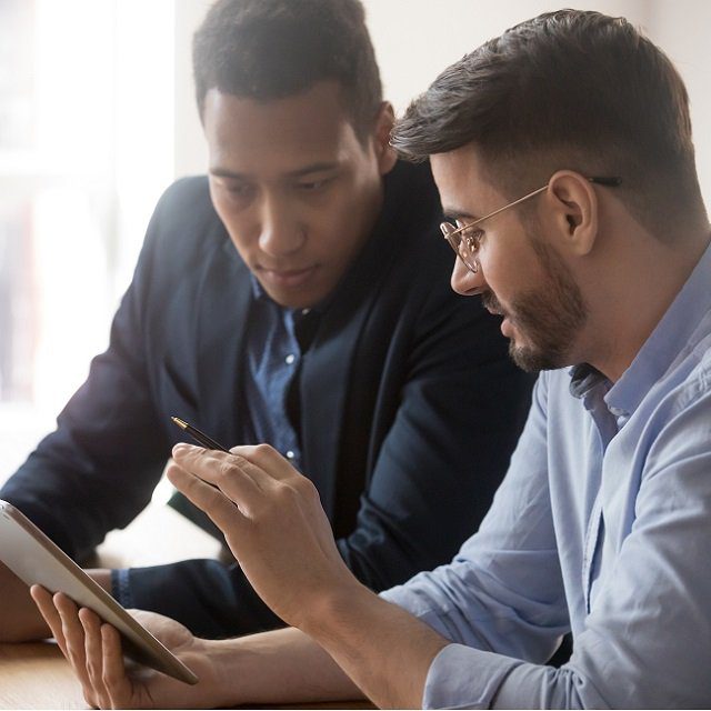 Two men look at a tablet