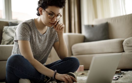 Young woman in living room on laptop