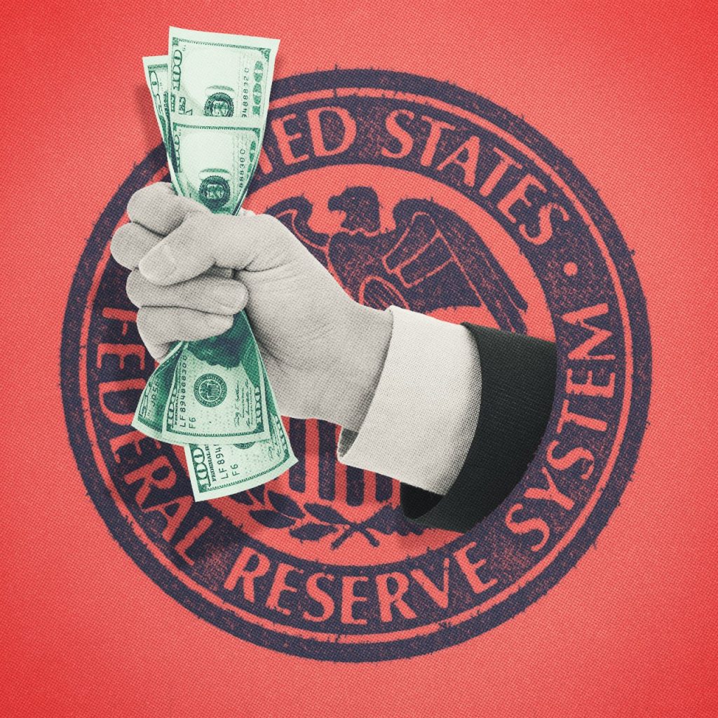 Hand crushing money on top of Federal Reserve seal