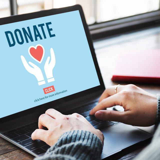 A person with a laptop donating to a charity