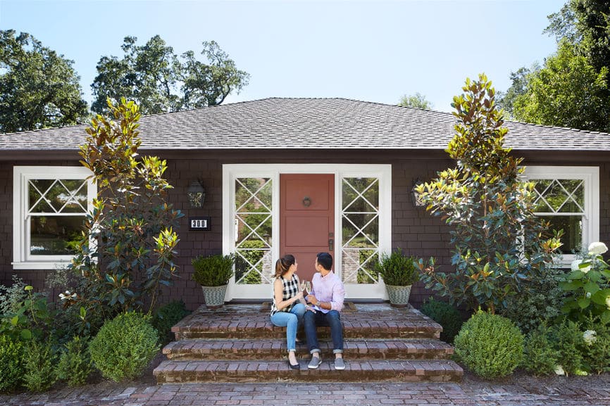 Couple sitting on the front steps of their new home