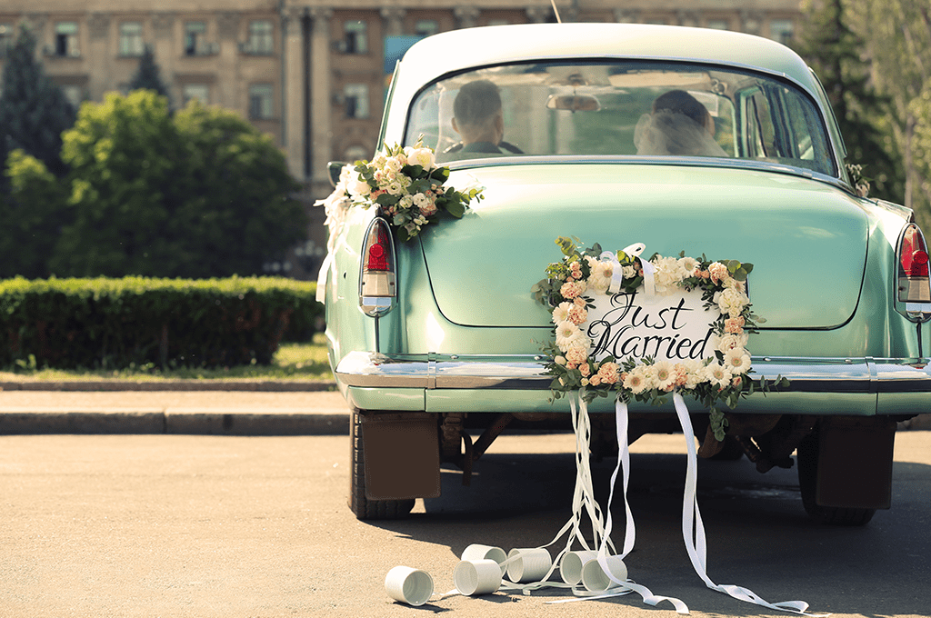 an image of the rear of a classic wedding car with a Just Married sign on the back