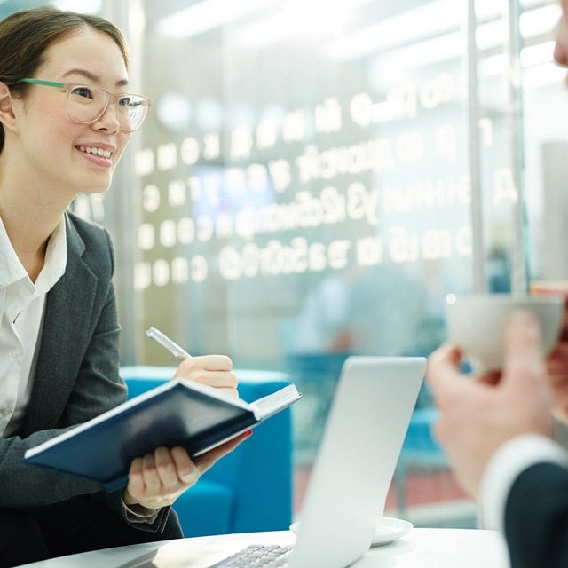 An advisor with a client taking notes.