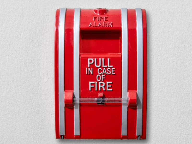 Fire alarm mounted on wall. In case of fire, pull
