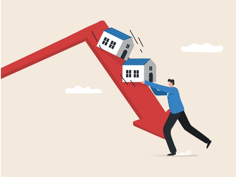 Insurance professional holds two houses up, and prevents them from crashing along a downfacing arrow, a symbol of the recession,