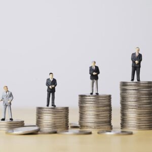 figures of businessmen standing on stacks of coins