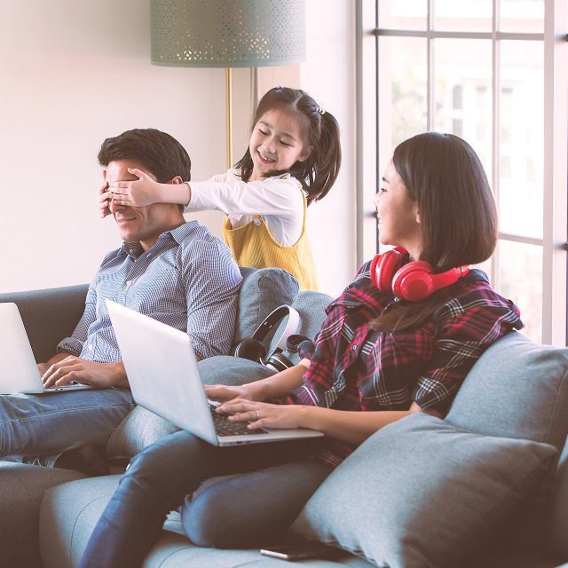 A father, a mother and a child, with two laptops.