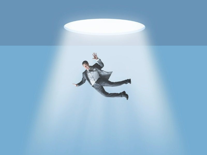 Businessman falls through an opening in the ceiling above him.