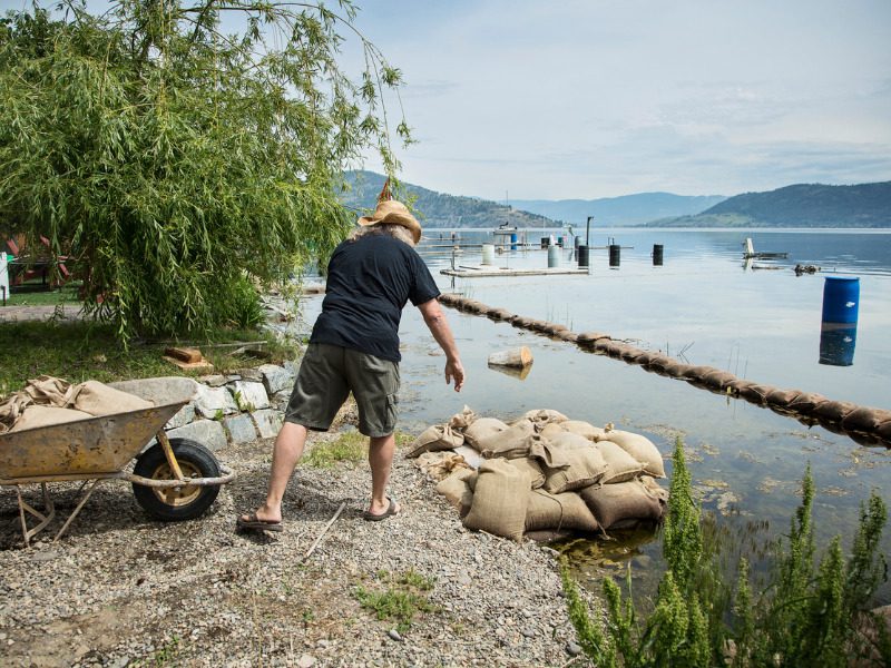 Man tossing sandbags from wheelbarrow to help prevent flooding