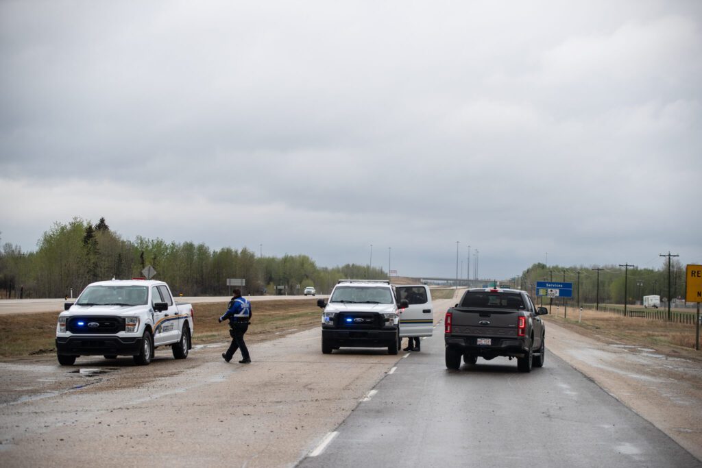 Police block the road into the wildfires near Entwhistle Alberta on Sunday May 7, 2023. THE CANADIAN PRESS/Jason Franson.
