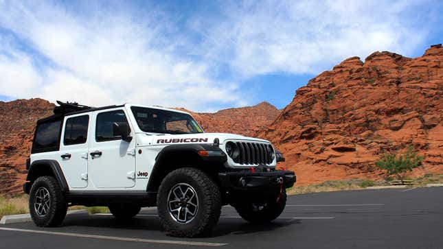 A photo of a white Jeep Wrangler parked in a canyon.