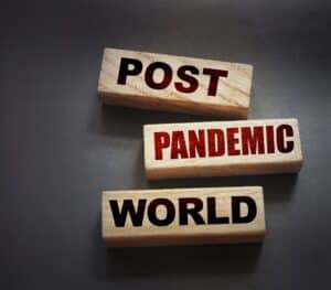 three wood blocks with the words "post," "pandemic," and "world" written on them in alternating black and red