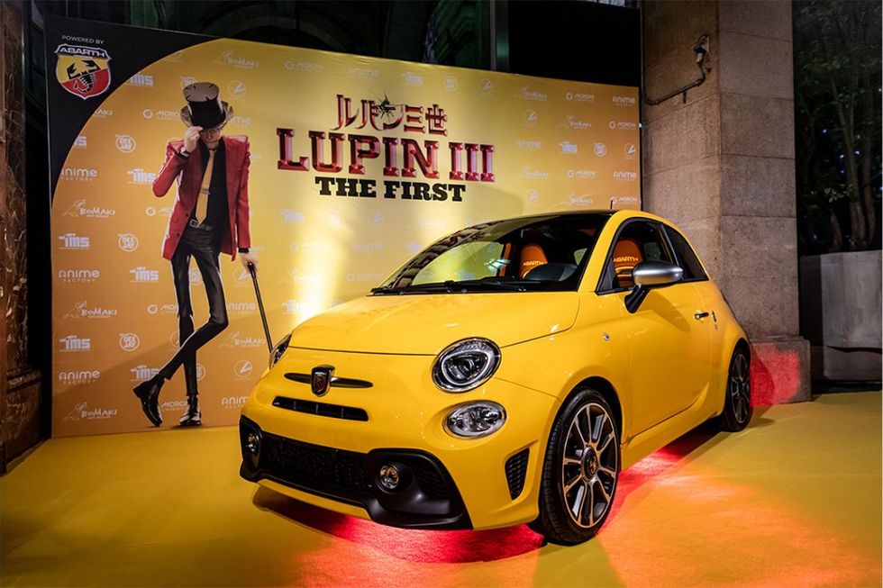 yellow fiat parked in front of lupin poster yellow fiat parked in front of lupin poster