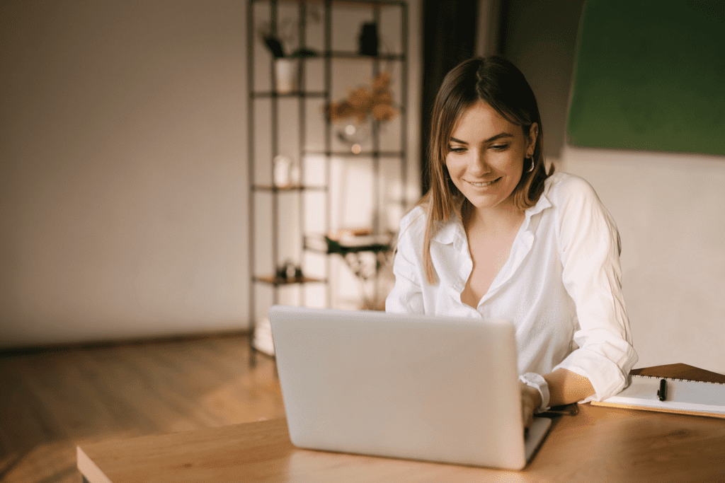 Happy Young Woman Working On A Laptop from home