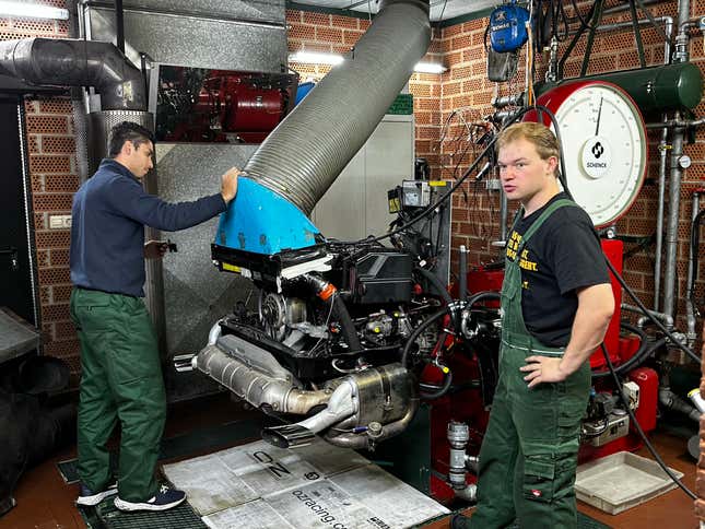 Two Ruf dyno techs prepare a turbocharged engine to go on the dyno