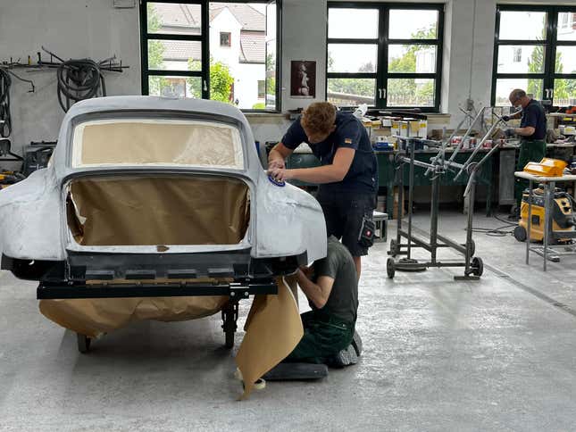 Men working in the Ruf body shop, shaping a fender