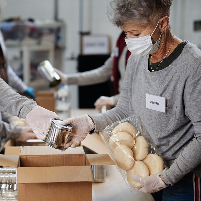 A volunteer packages food at a food bank.