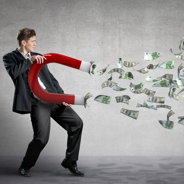 Businessman with magnet attracting money
