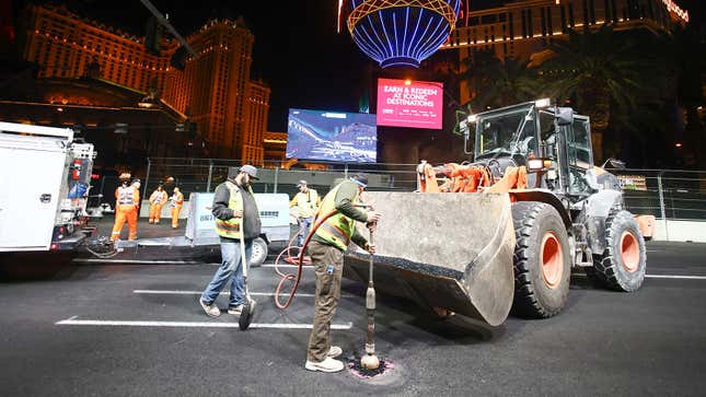 A photo of crews working to fill a drain cover on the Las Vegas strip. 