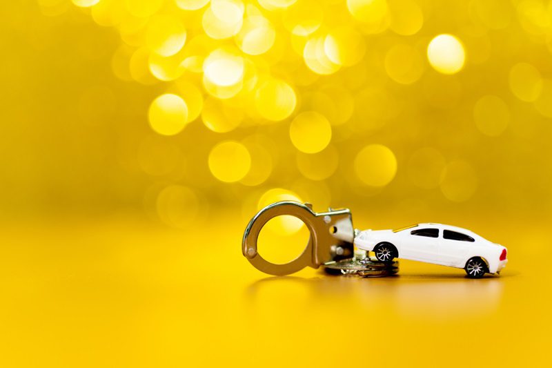 auto and handcuffs on shiny background.