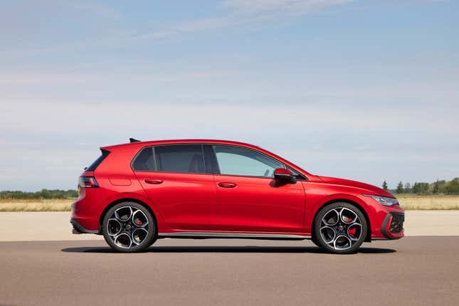 A side view of the new GTI in bright red near a field